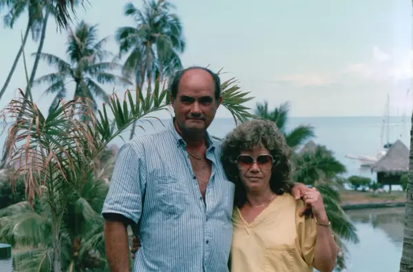 Mario R. Alvarez, Sr. by the water under palm trees